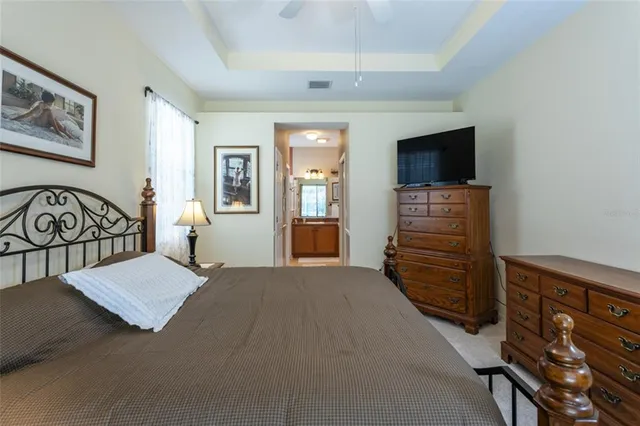 a bedroom with a bed and a flat tv screen on dresser