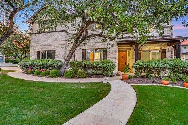 a front view of a house with a yard and potted plants