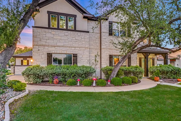 a front view of a house with a yard and potted plants