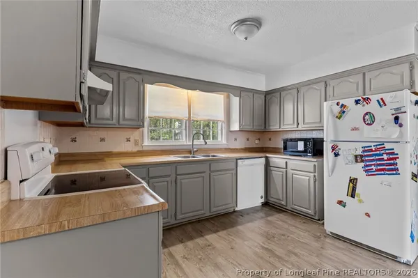 a kitchen with granite countertop a sink a window stainless steel appliances and cabinets