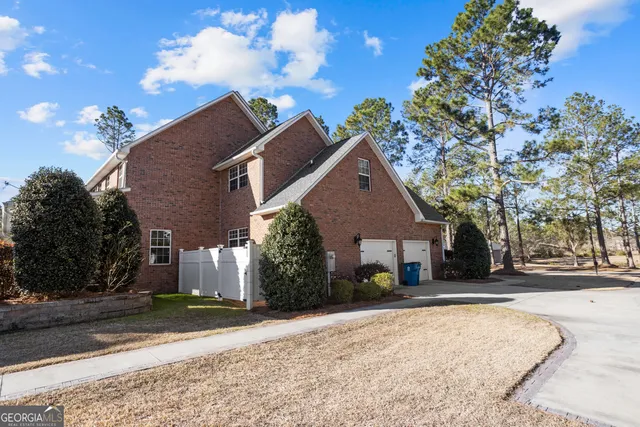 an aerial view of residential houses with outdoor space and trees