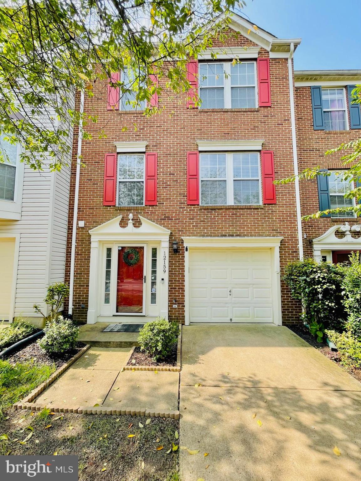 12159 Drum Salute Place Bristow, VA 20136 - Photo 1 of 36 a front view of a house with a yard and garage