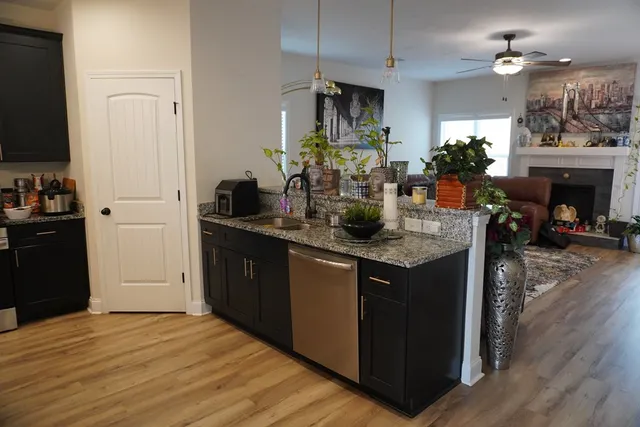 a kitchen with kitchen island a counter top space a sink stainless steel appliances and cabinets