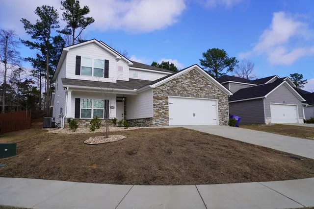 a front view of a house with yard and garage