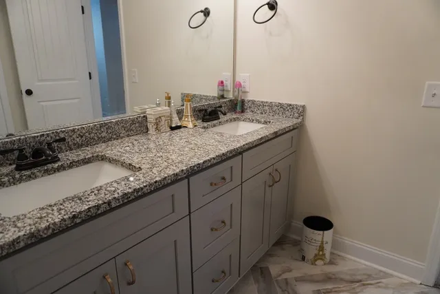 a bathroom with a granite countertop sink and a mirror