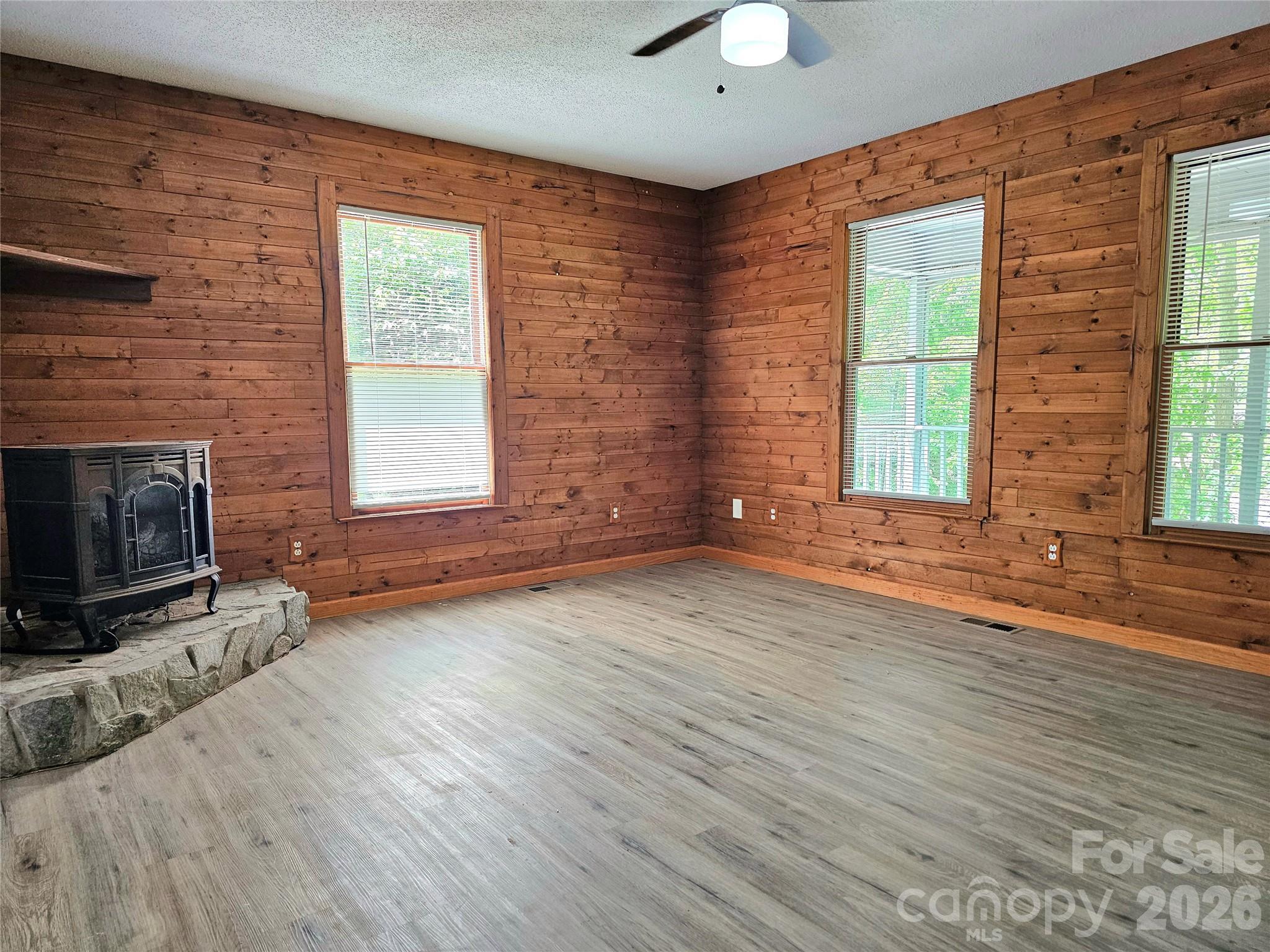 5692 S-141 Great Falls, SC 29055 - Photo 16 of 48 an empty room with windows fireplace and wooden floor