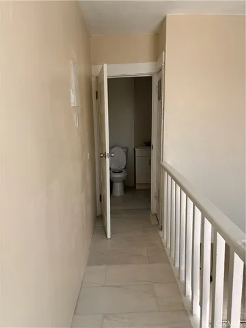 a view of a hallway with a livingroom and a bathroom