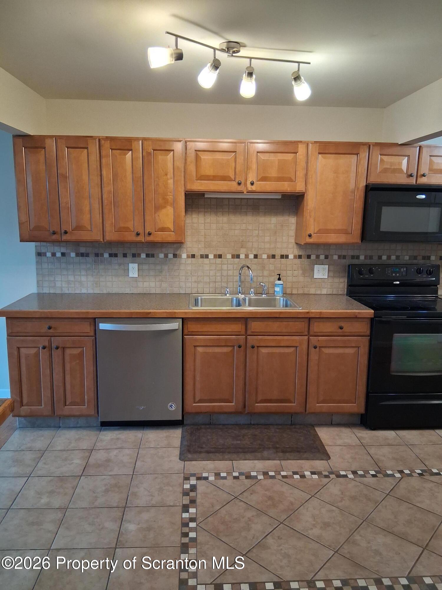 512 South Keyser Avenue Scranton, PA 18504 - Photo 15 of 42 a kitchen with a sink a stove and cabinets