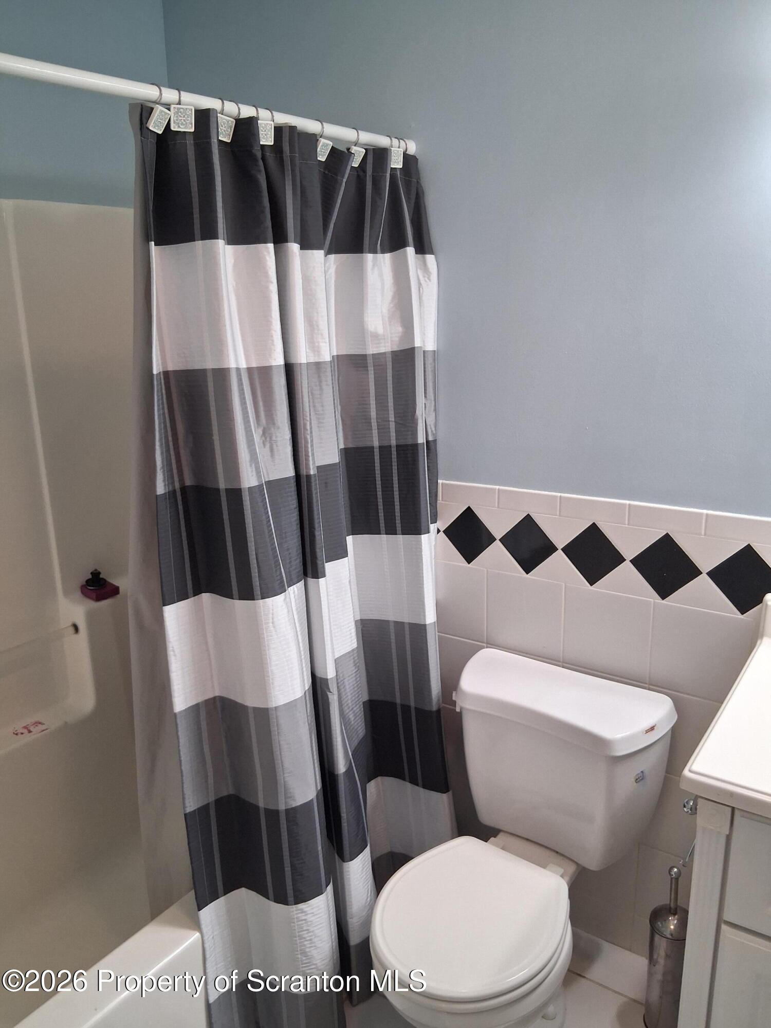 512 South Keyser Avenue Scranton, PA 18504 - Photo 33 of 42 a white toilet sitting next to a shower curtain