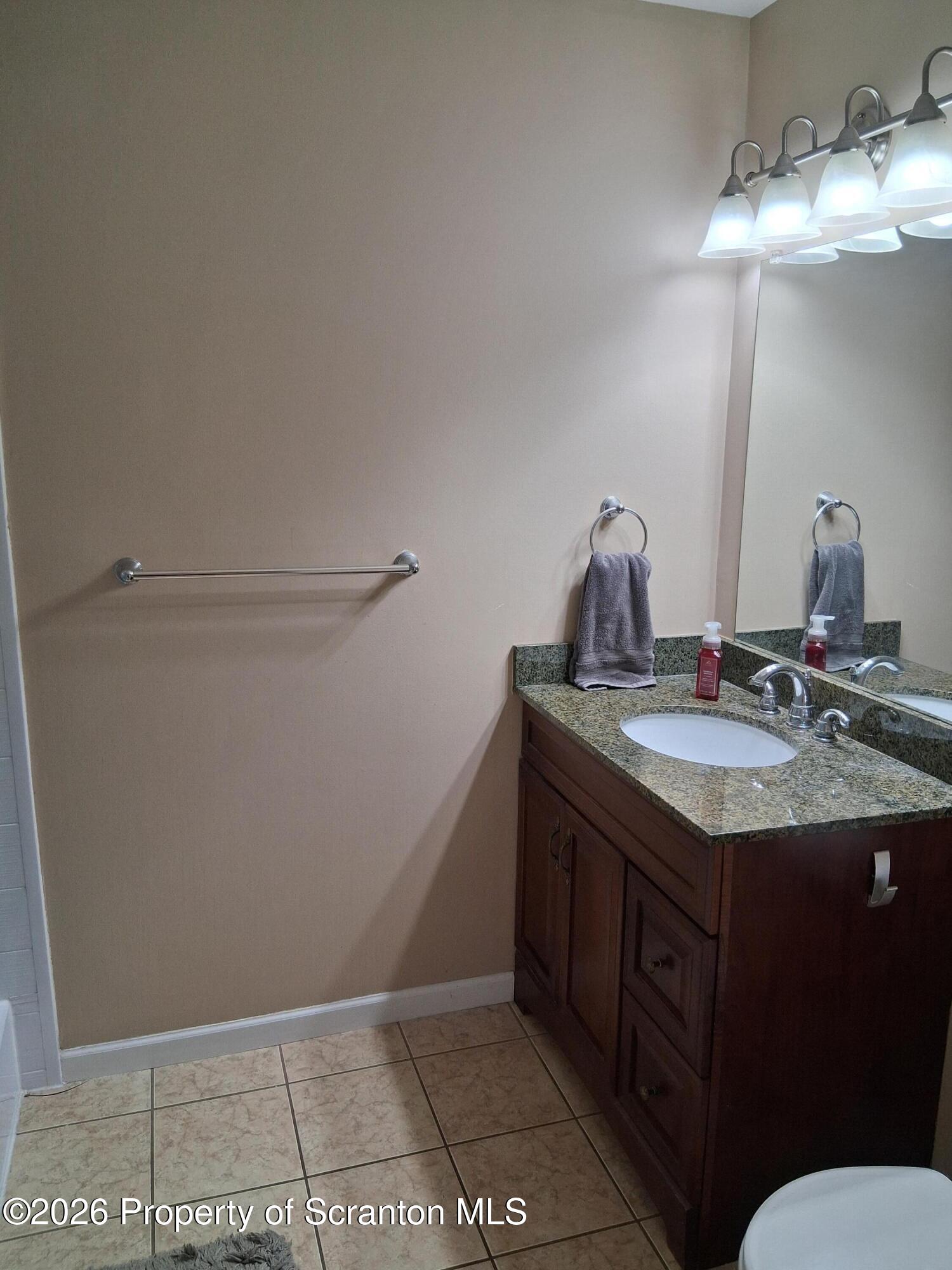 512 South Keyser Avenue Scranton, PA 18504 - Photo 36 of 42 a bathroom with a granite countertop sink a toilet and a mirror