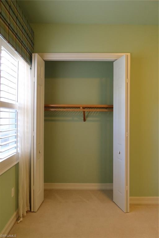 7168 Lemuria Circle, Unit 1701 Naples, FL 34109 - Photo 26 of 39 Bifold closet doors revealing an interior storage rod and shelving