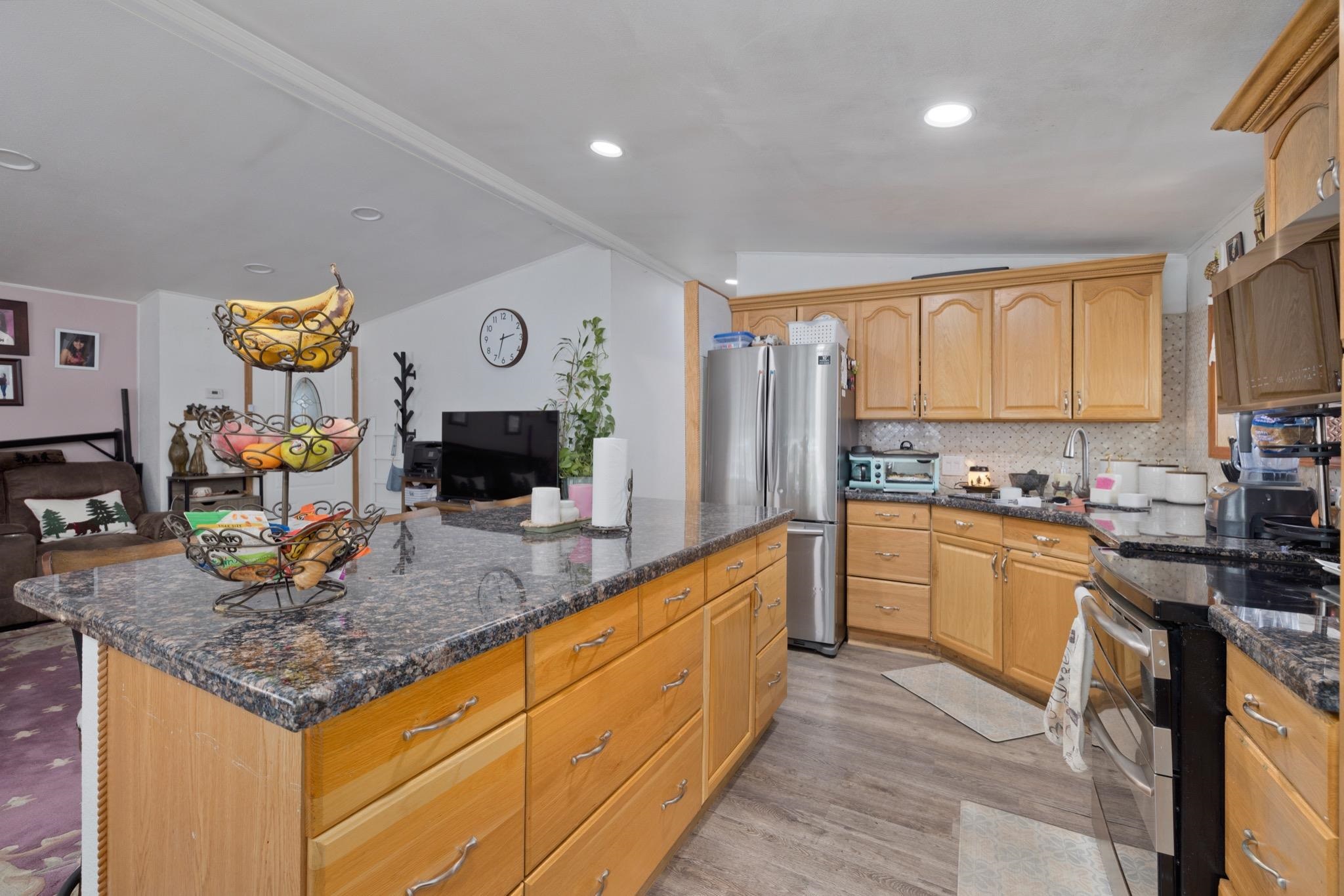 100 Ski Trails Road, Unit 10 Mammoth Lakes, CA 93546 - Photo 11 of 26 Kitchen featuring wood-finish cabinetry, granite countertops, stainless steel refrigerator, and wood-look flooring