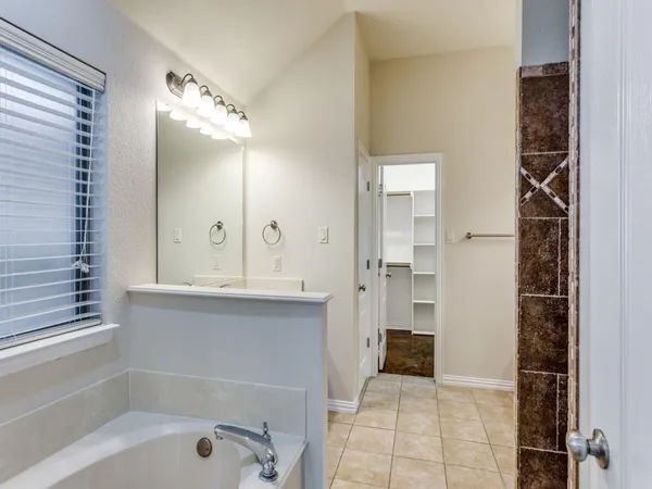 a bathroom with a tub shower and sink