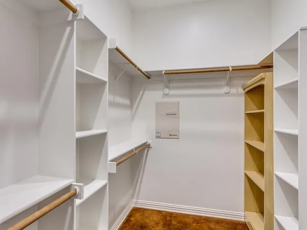 a view of walk in closet with clothes and shoes