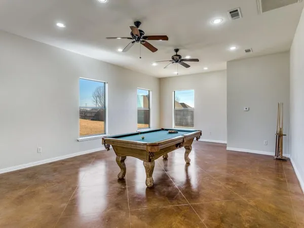 a room with wooden floor and pool table