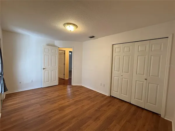 a view of an empty room with wooden floor