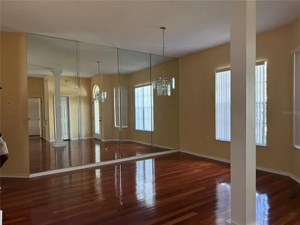 a view of a room with wooden floor and fan