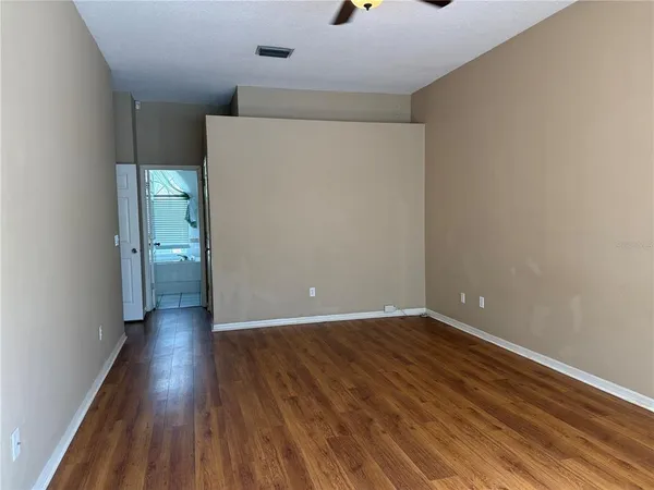 a view of an empty room with wooden floor