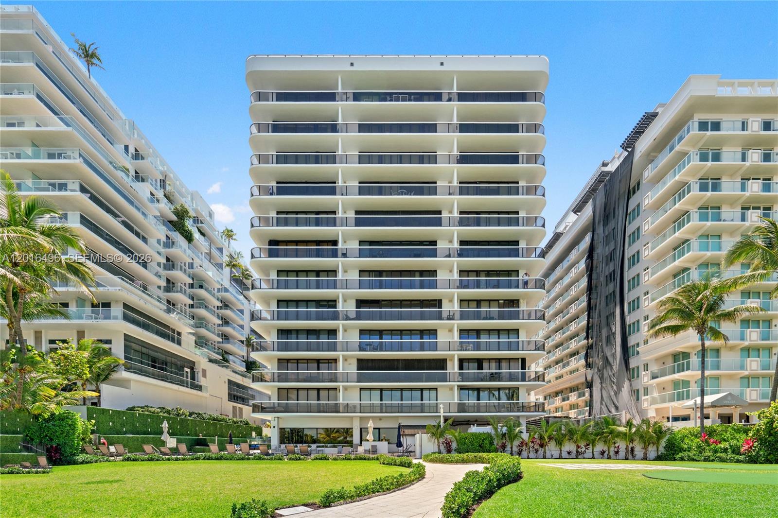 9455 Collins Avenue, Unit 310 Surfside, FL 33154 - Photo 1 of 19 a view of a tall building with a yard and potted plants