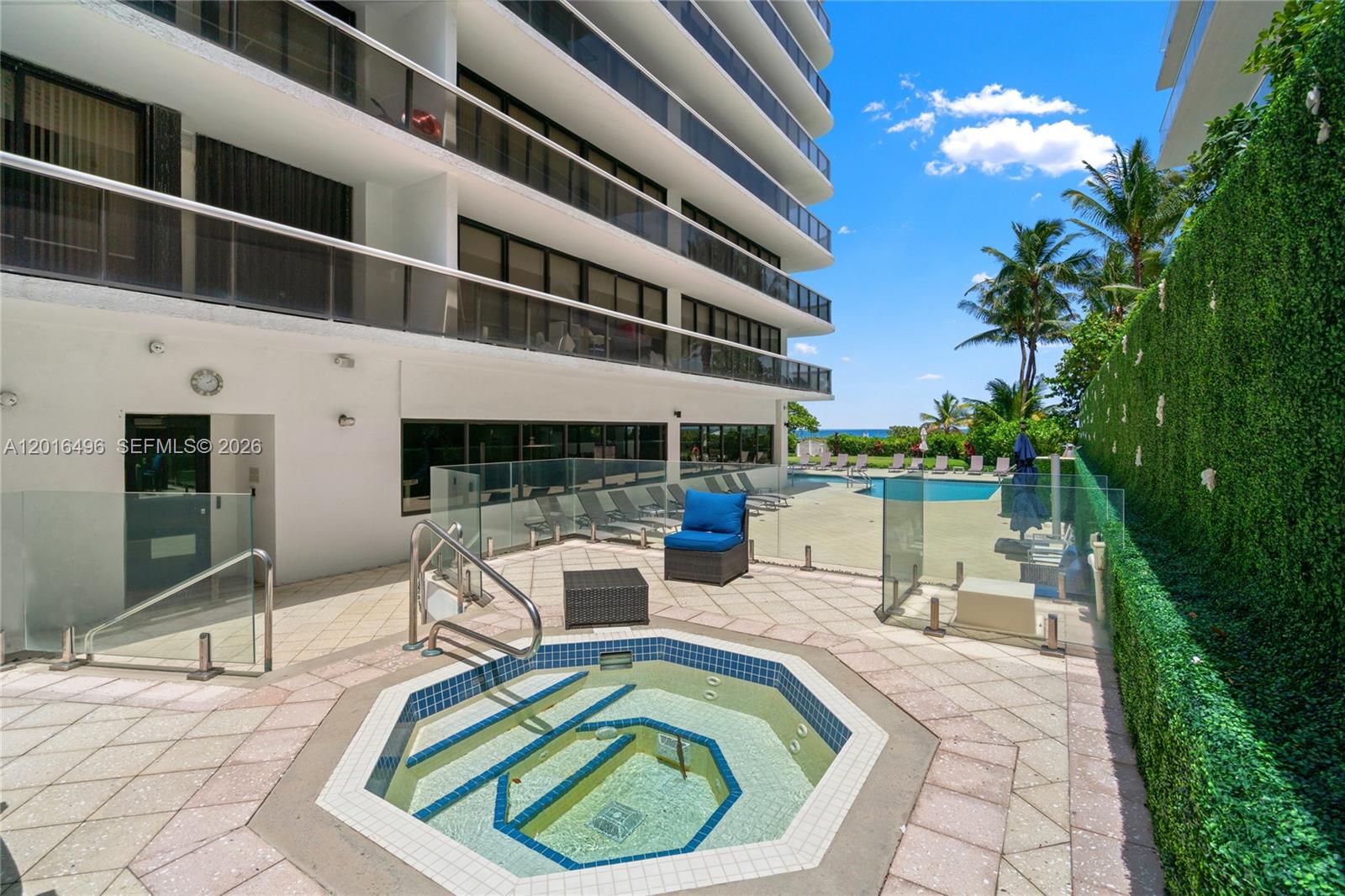 9455 Collins Avenue, Unit 310 Surfside, FL 33154 - Photo 8 of 19 a view of a swimming pool with a lounge chairs