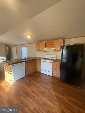 a kitchen with stainless steel appliances granite countertop a refrigerator a sink and a stove