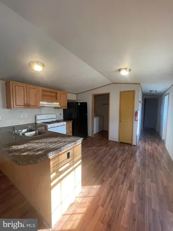 a kitchen with stainless steel appliances granite countertop a sink stove and wooden floor