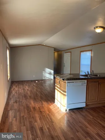 a kitchen with granite countertop a stove and a wooden floors
