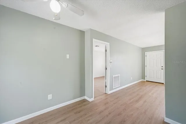 a view of an empty room with wooden floor
