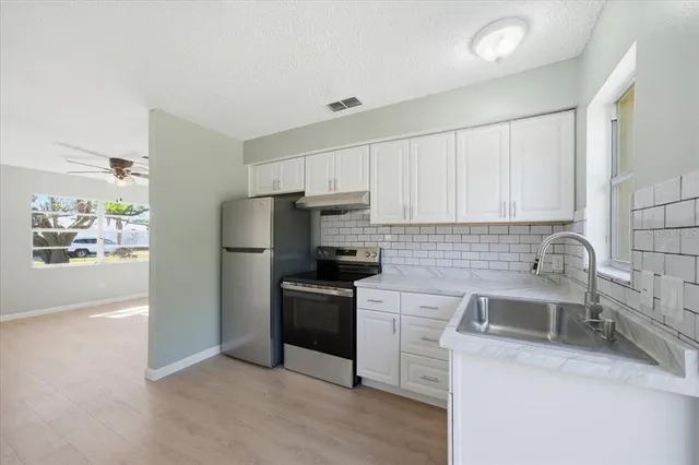 a kitchen with granite countertop a sink stove and refrigerator
