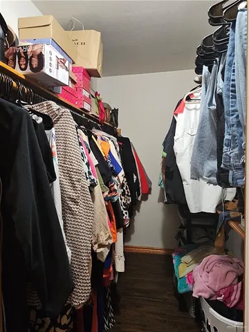 a view of walk in closet with clothes and shoes