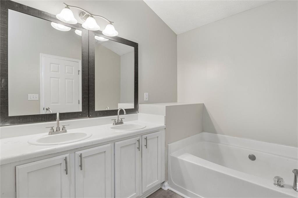 5667 Cascade Run Atlanta, GA 30336 - Photo 18 of 31 a bathroom with a sink a tub and a mirror