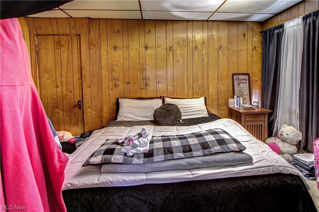 3816 Riverside Avenue Cleveland, OH 44109 - Photo 19 of 35 Bedroom with wooden walls and a drop ceiling