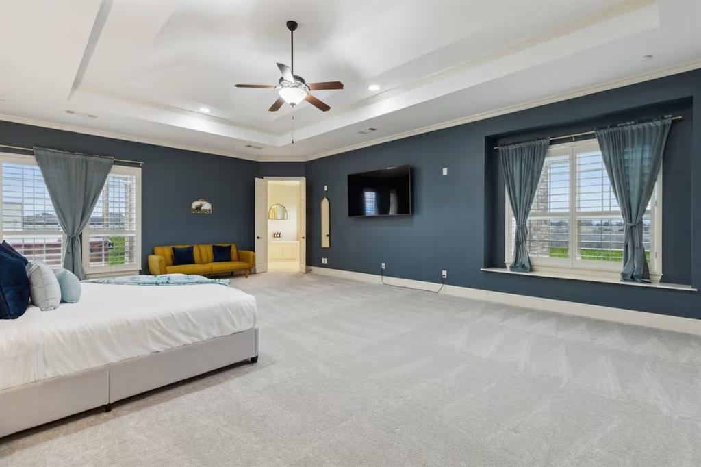 1405 Gateway Boulevard Forney, TX 75126 - Photo 16 of 32 a bedroom with a large bed chandelier and window