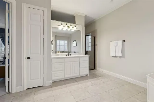 a bedroom with a large bed chandelier and window