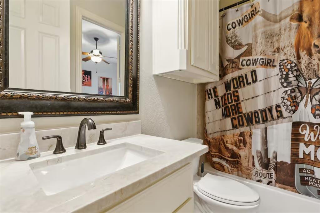 1405 Gateway Boulevard Forney, TX 75126 - Photo 26 of 32 a bathroom with a sink a toilet and a mirror