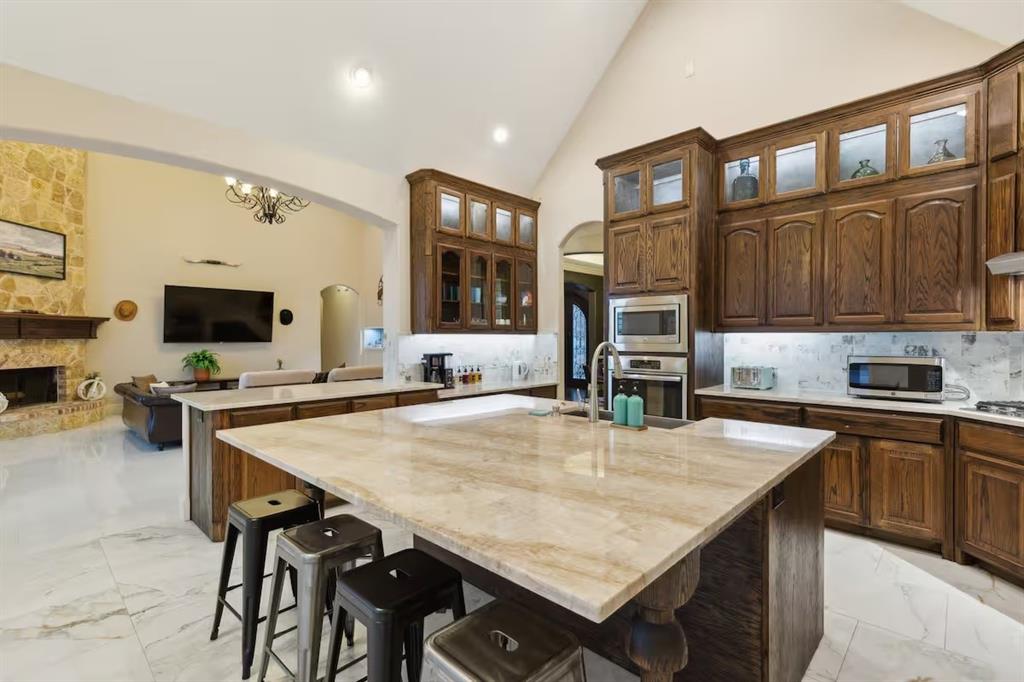 1405 Gateway Boulevard Forney, TX 75126 - Photo 32 of 32 a kitchen with stainless steel appliances granite countertop a stove a refrigerator a kitchen island a stove and cabinets