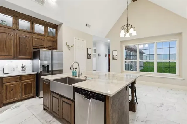 a kitchen with stainless steel appliances granite countertop a stove a refrigerator a kitchen island a stove and cabinets