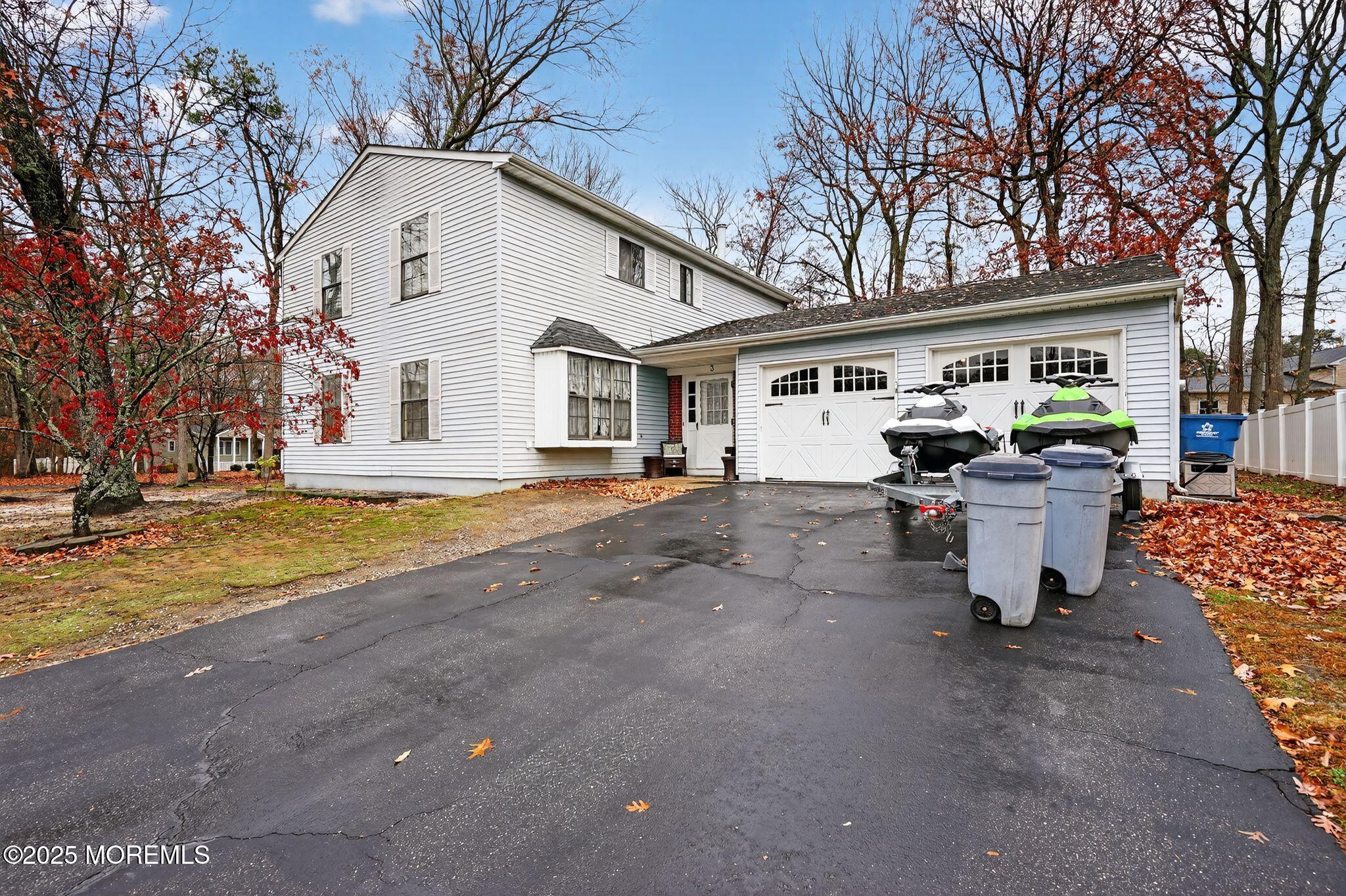 a front view of a house with garage and chair