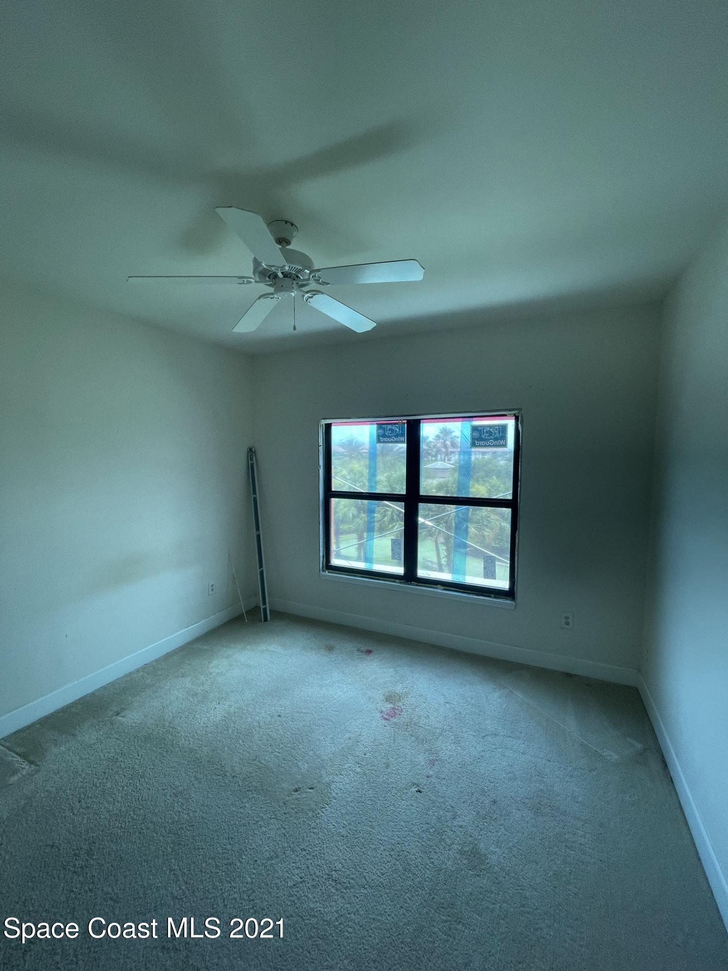 6411 Borasco Drive, Unit 319 Melbourne, FL 32940 - Photo 11 of 27 an empty room with a empty space and windows