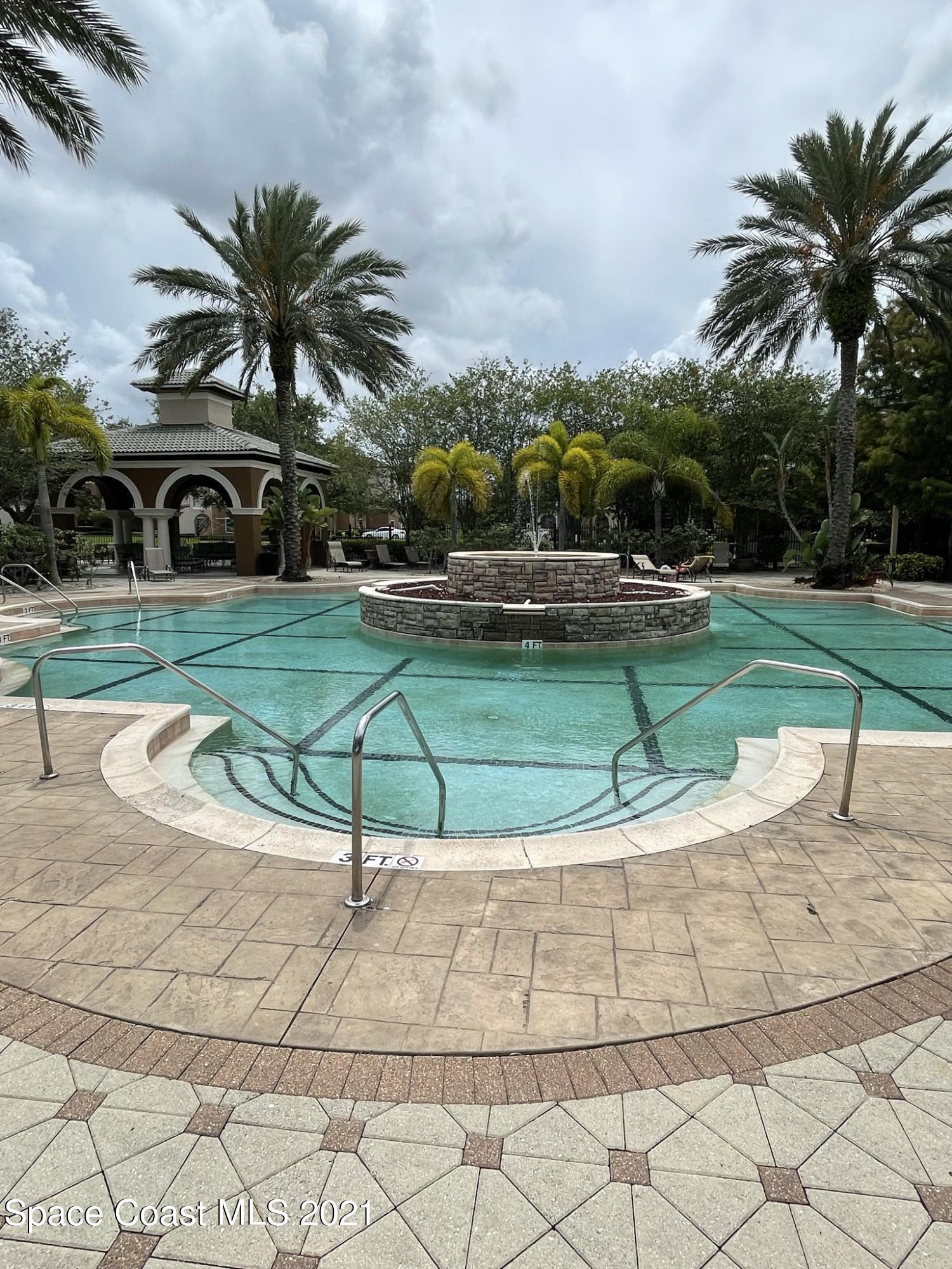 6411 Borasco Drive, Unit 319 Melbourne, FL 32940 - Photo 19 of 27 a house with palm tree in front of it