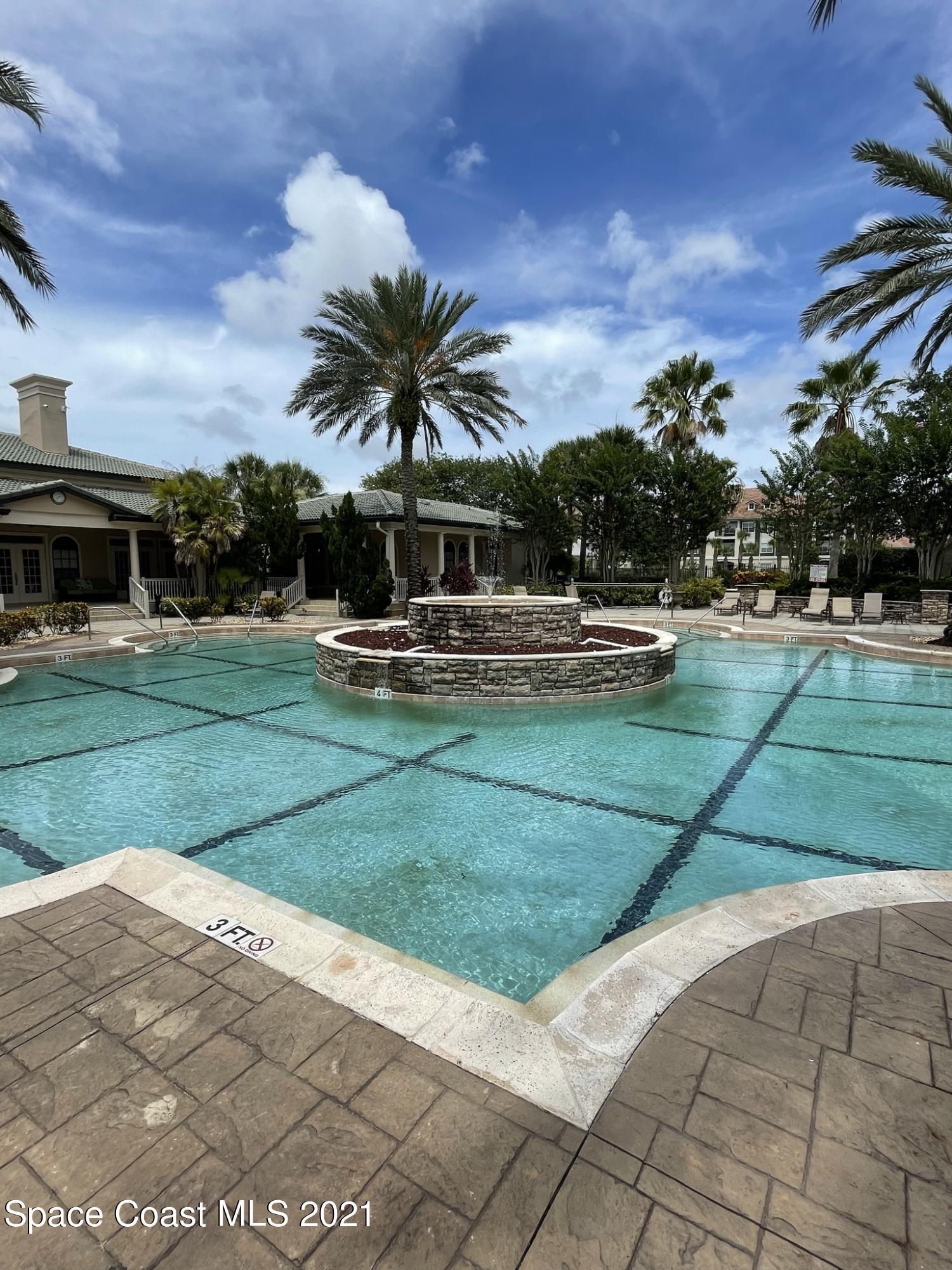 6411 Borasco Drive, Unit 319 Melbourne, FL 32940 - Photo 24 of 27 a view of a swimming pool with a garden