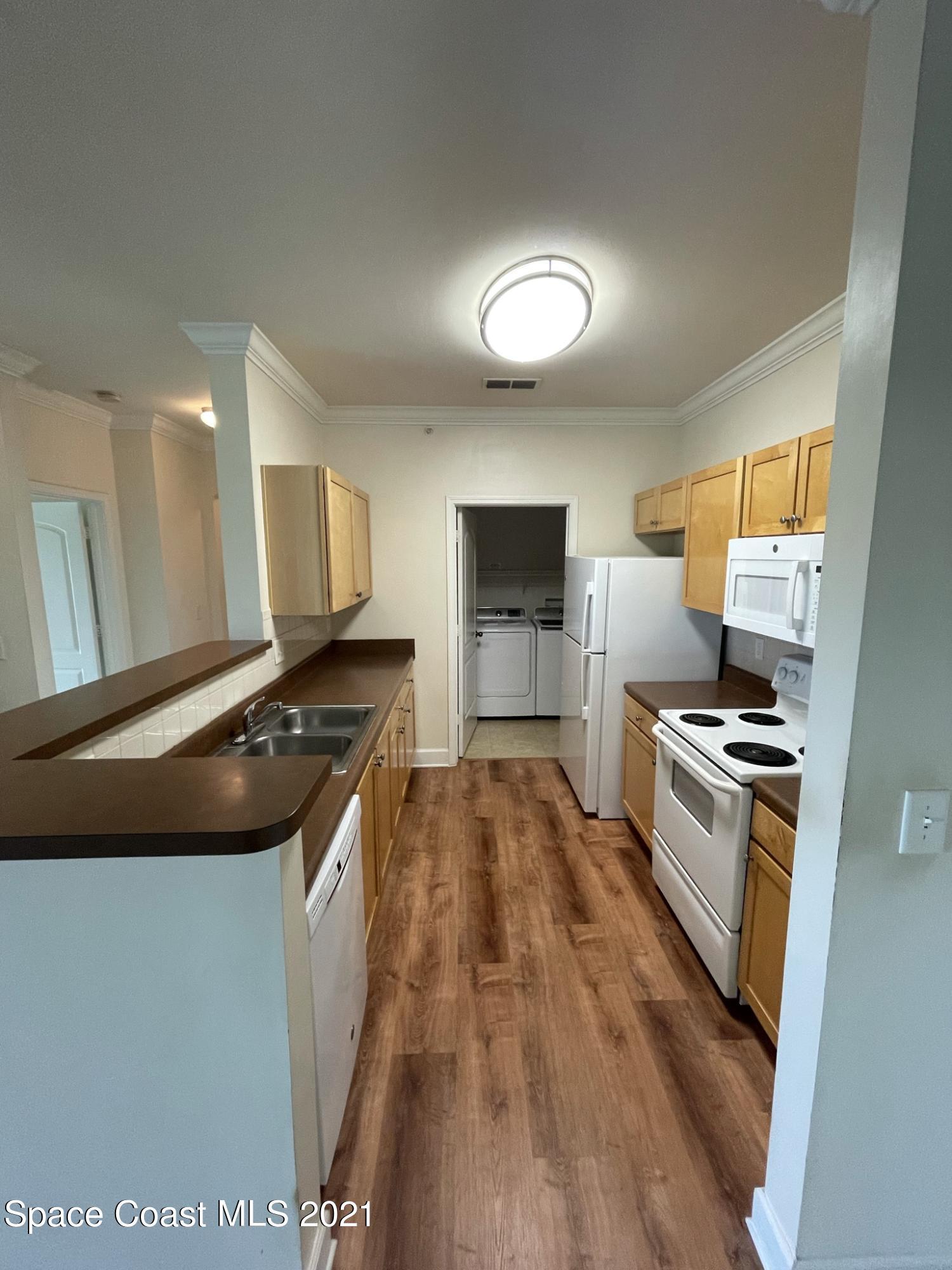 6411 Borasco Drive, Unit 319 Melbourne, FL 32940 - Photo 8 of 27 a kitchen with a stove and a refrigerator