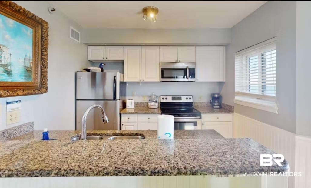 375 Plantation Road, Unit 5814 Gulf Shores, AL 36542 - Photo 11 of 31 Kitchen featuring stone counters, appliances with stainless steel finishes, sink, and white cabinets