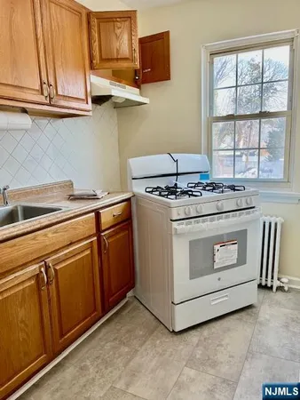 a white stove top oven sitting inside of a kitchen