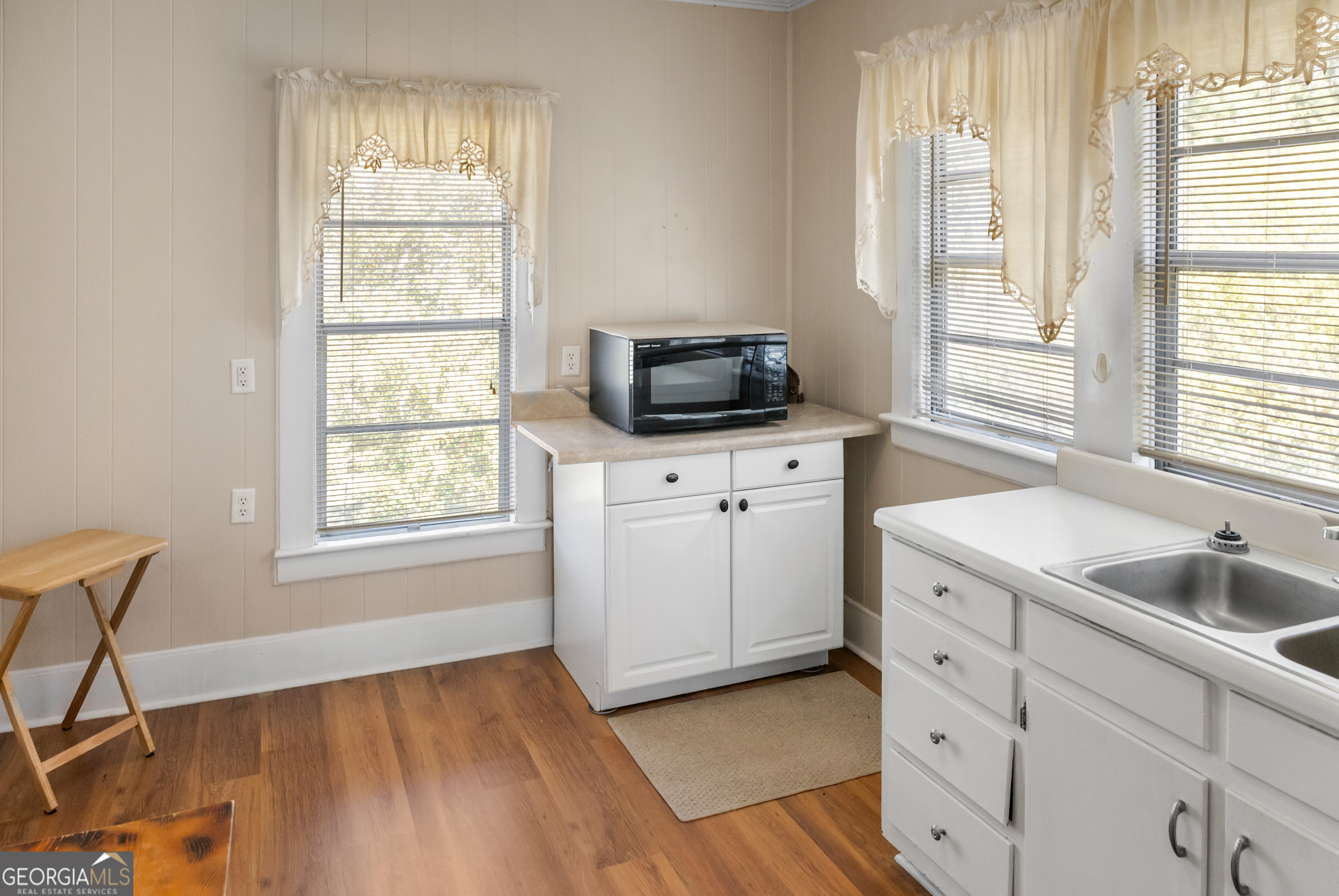 17332 Old River Road North Statesboro, GA 30461 - Photo 18 of 26 a kitchen with a sink wooden cabinets and a window