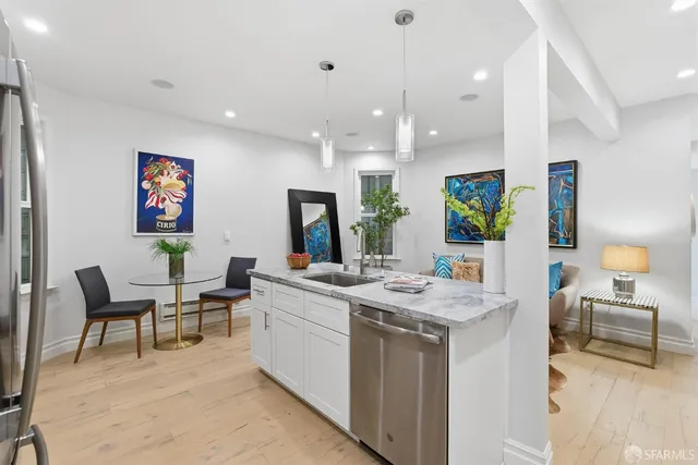 a view of living room kitchen with stainless steel appliances granite countertop furniture and a couch