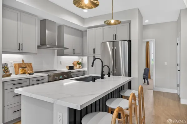 a kitchen with stainless steel appliances a sink a stove a refrigerator and cabinets