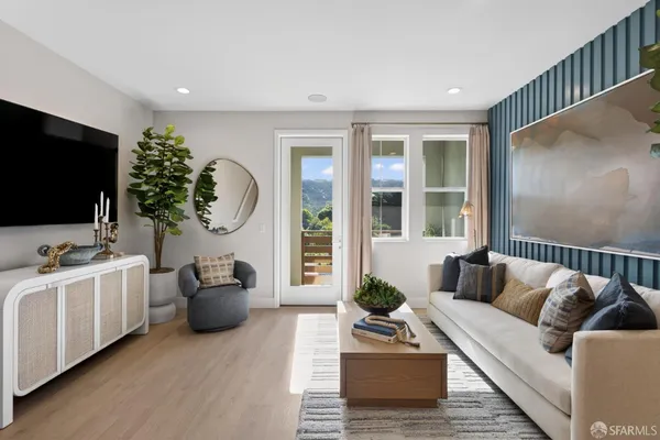 a living room with furniture a flat screen tv and a potted plant