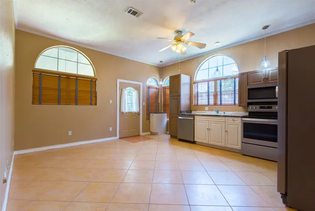 a view of a kitchen with a sink and dishwasher a refrigerator with white cabinets