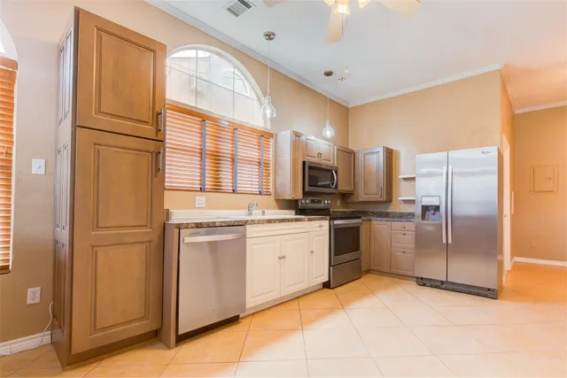 a kitchen with stainless steel appliances granite countertop a refrigerator and a stove top oven